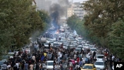 Nan foto sa a ke yon moun ki pa travay pou Associated Press pran andeyo Iran, manifestan ap chante slogan pandan yap pwoteste kont lanmo yon dam lapolis te arete pou moralite nan Teheran, Iran, 21 Sept. 2022. 